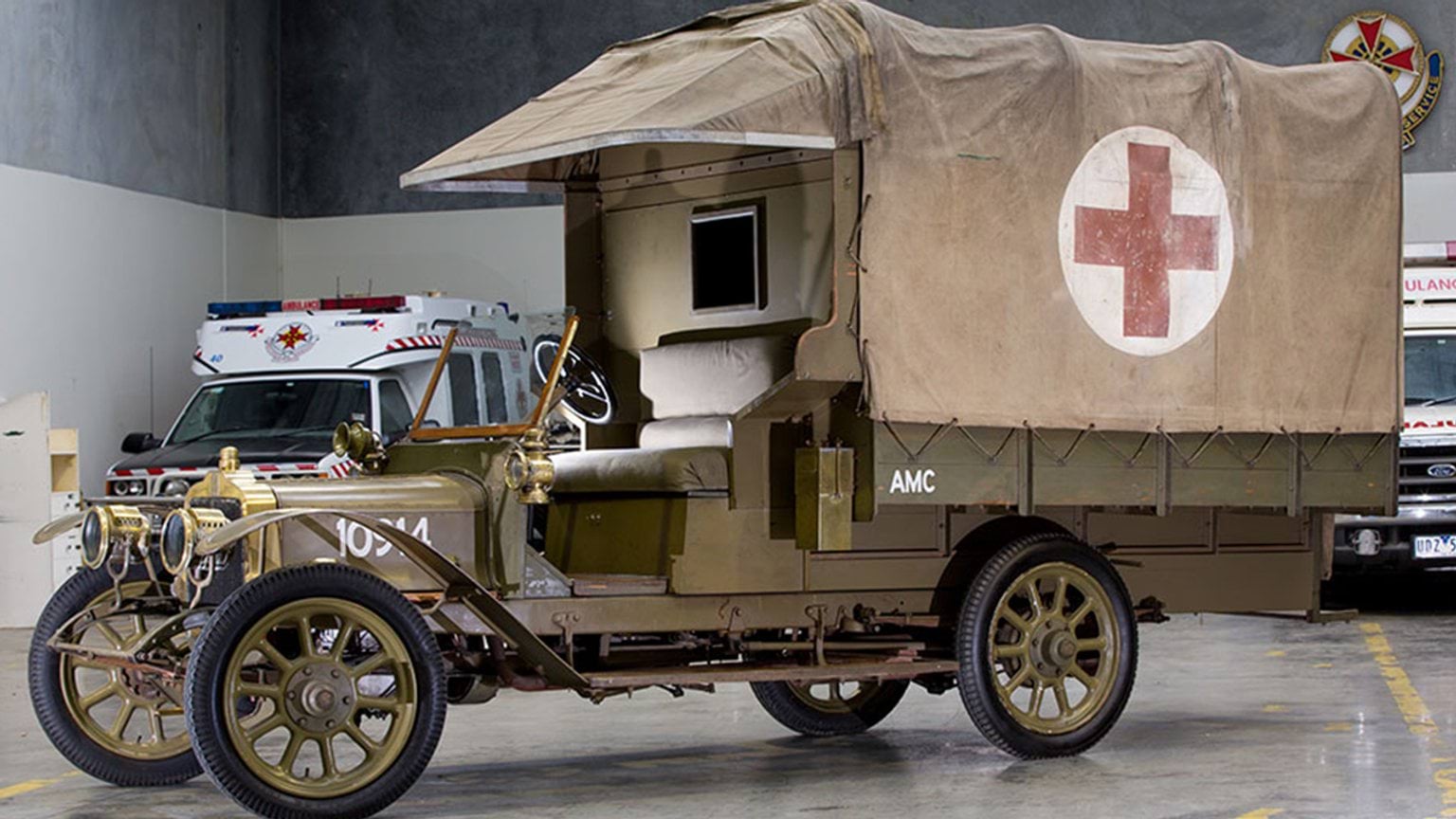 An old-fashioned ambulance parked inside a garage, showcasing its vintage design and classic features.