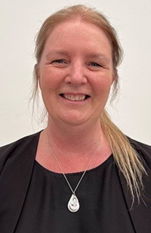 A woman smiles at the camera