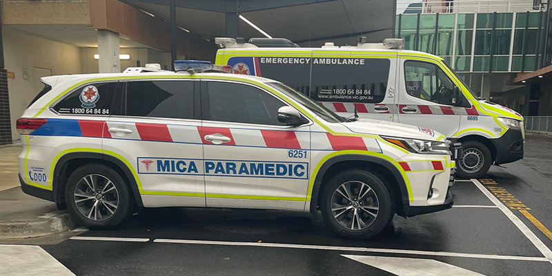 An Ambulance Victoria utility vehicle and an ambulance parked at a hospital.