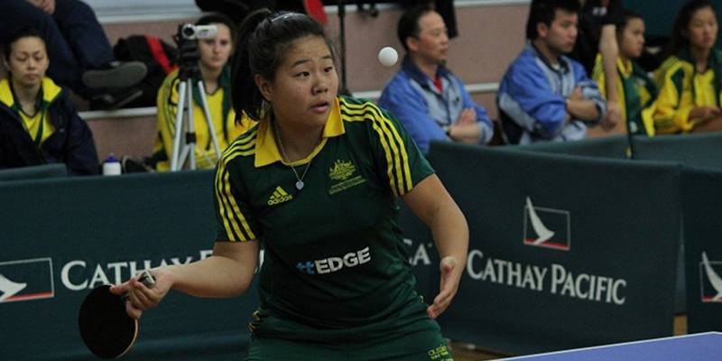 A female athlete serving ball in a table tennis tournament.