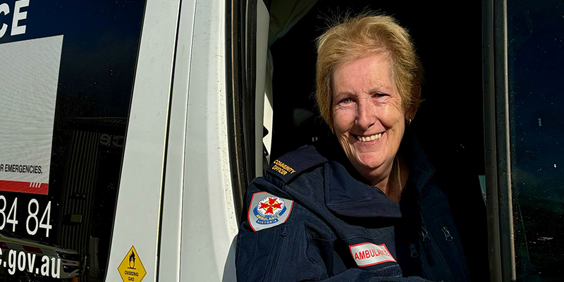 A female paramedic in the driver's seat of an ambulance.