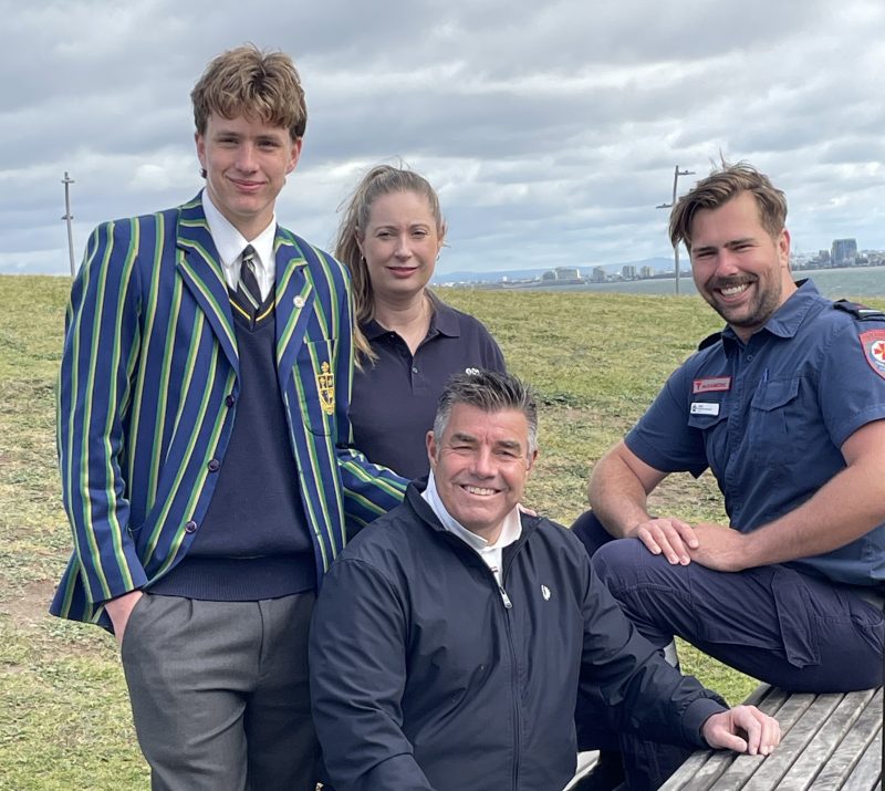 Four people posed at a picnic table, smiling for the camera.