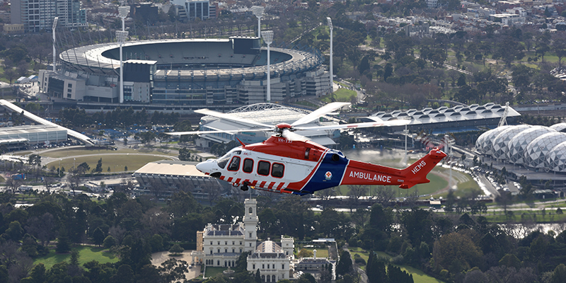 An ambulance helicopter flying over a stadium in Melbourne city.