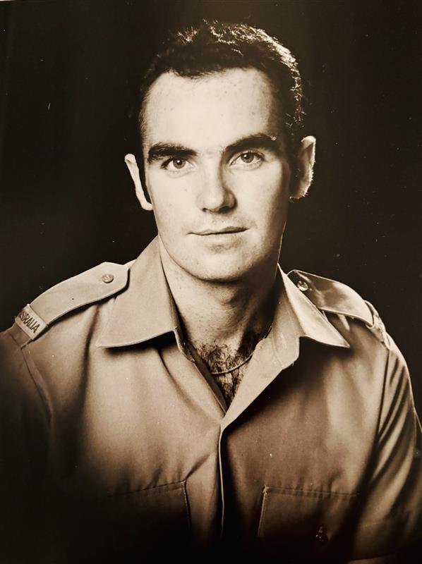 A black and white portrait photo of a young man. His uniform includes epaulettes that say 'Australia'.