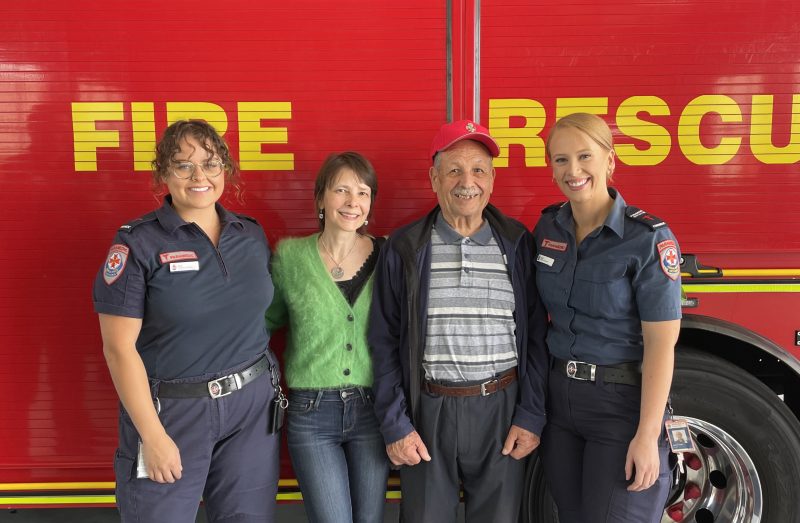 Four people in front of a fire truck.