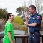 A paramedic communicating to a male through sign language.