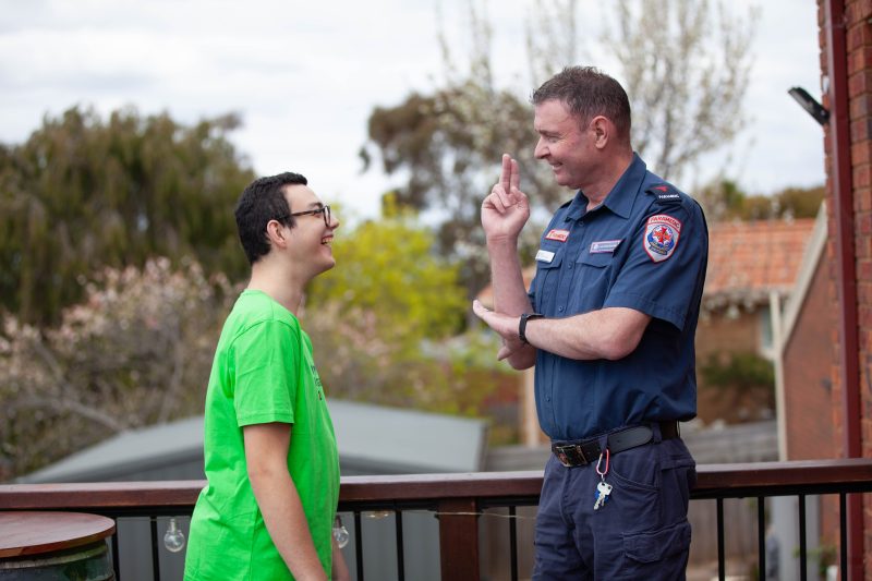 A paramedic communicating to a male through sign language.