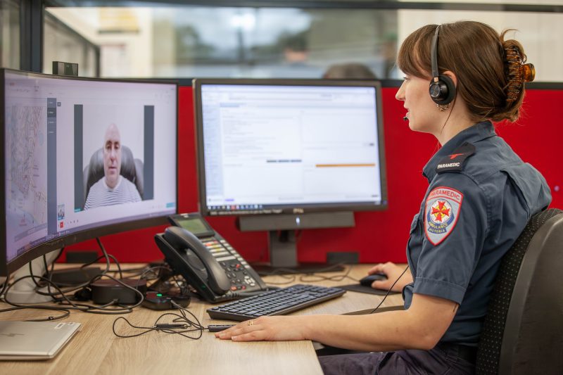 A woman talking to a man on the computer.