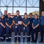 A group of paramedics holding a plaque.