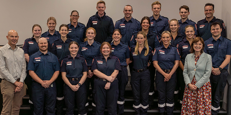 A group of people in paramedic uniform smiling for a photo.