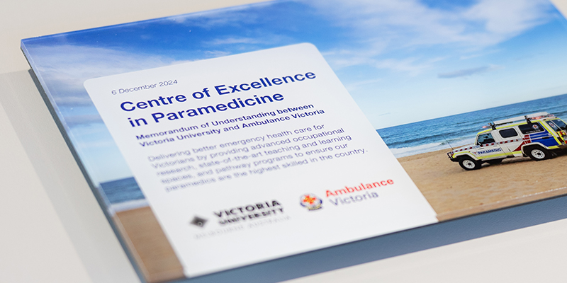 A plaque with a photo of a vehicle driven by paramedics that is on a beach with the ocean in the background.