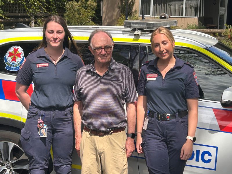 A man and two women standing in front of a car smiling.