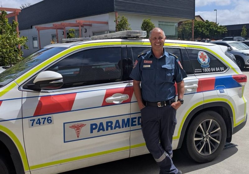 A man standing in front of an ambulance car.