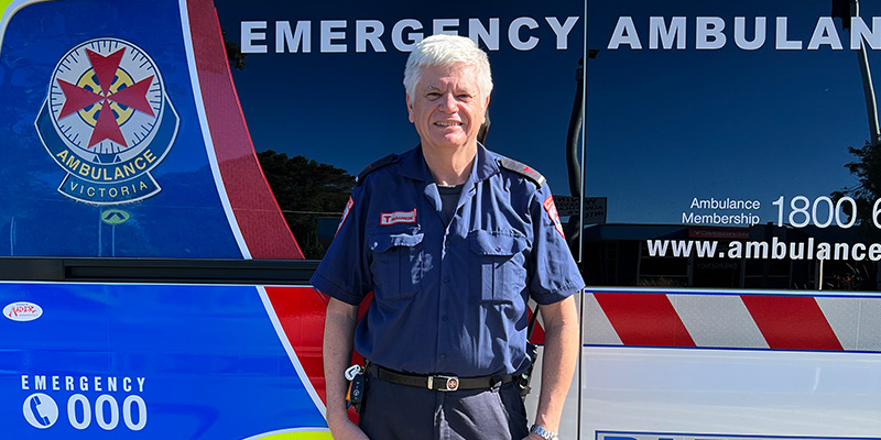 Kevin in uniform standing in front of an ambulance