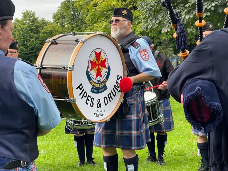 A man wearing a kilt and playing a drum.