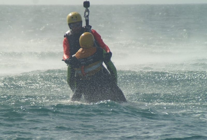 A man being winched from the ocean.