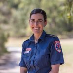 A smiling woman wearing a paramedic uniform.