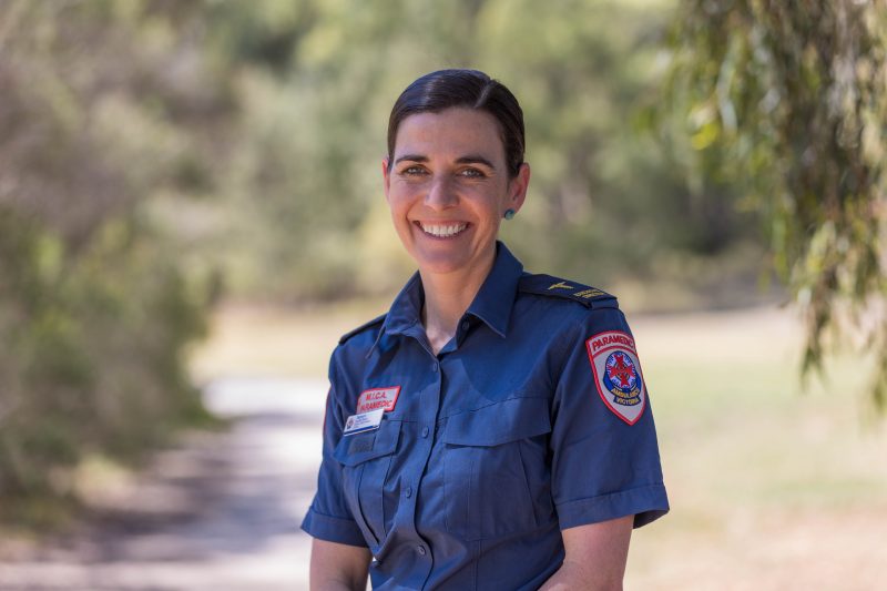 A smiling woman wearing a paramedic uniform.