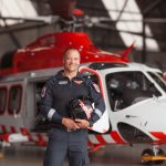 A man standing in front of a helicopter.