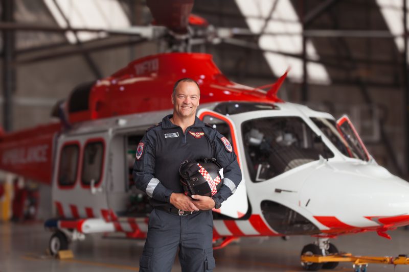 A man standing in front of a helicopter.