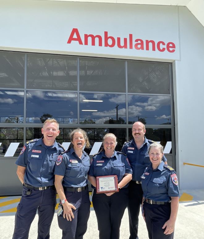 A group of smiling people holding a plaque.