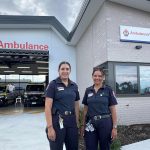 Two female paramedics outside an ambulance branch.