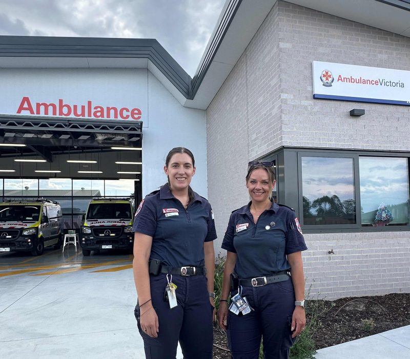 Two female paramedics outside an ambulance branch.