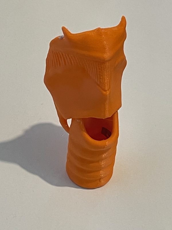 A 3D orange device with an opening in the middle.