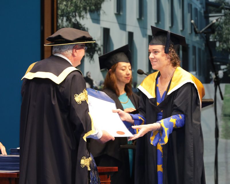 A woman receives her degree at a university graduation ceremony.