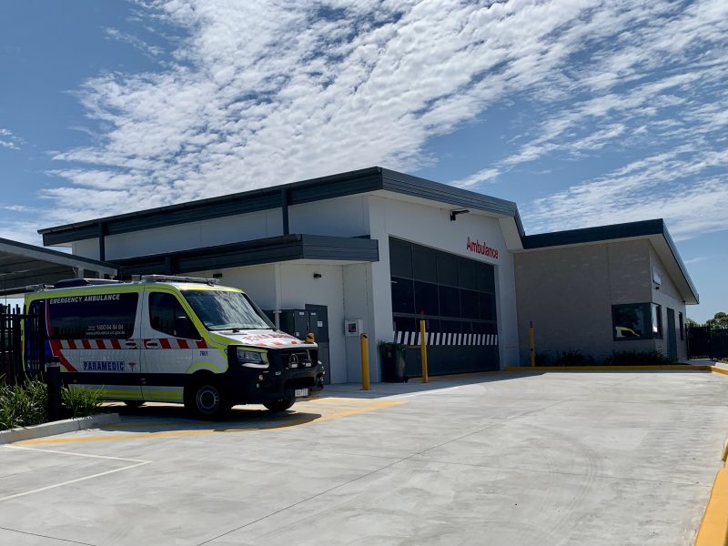 A photo from the driveway looking at the new ambulance branch. An ambulance is parked next to it.